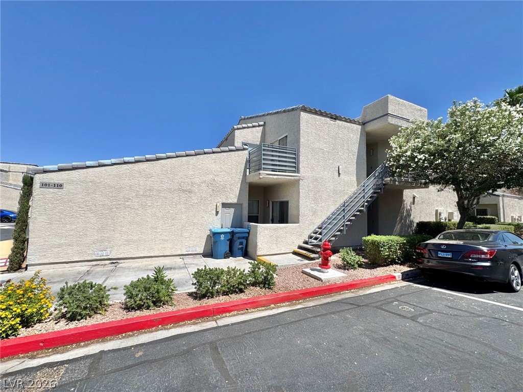 Multi-level residential building with well-maintained landscaping and open-air staircases.