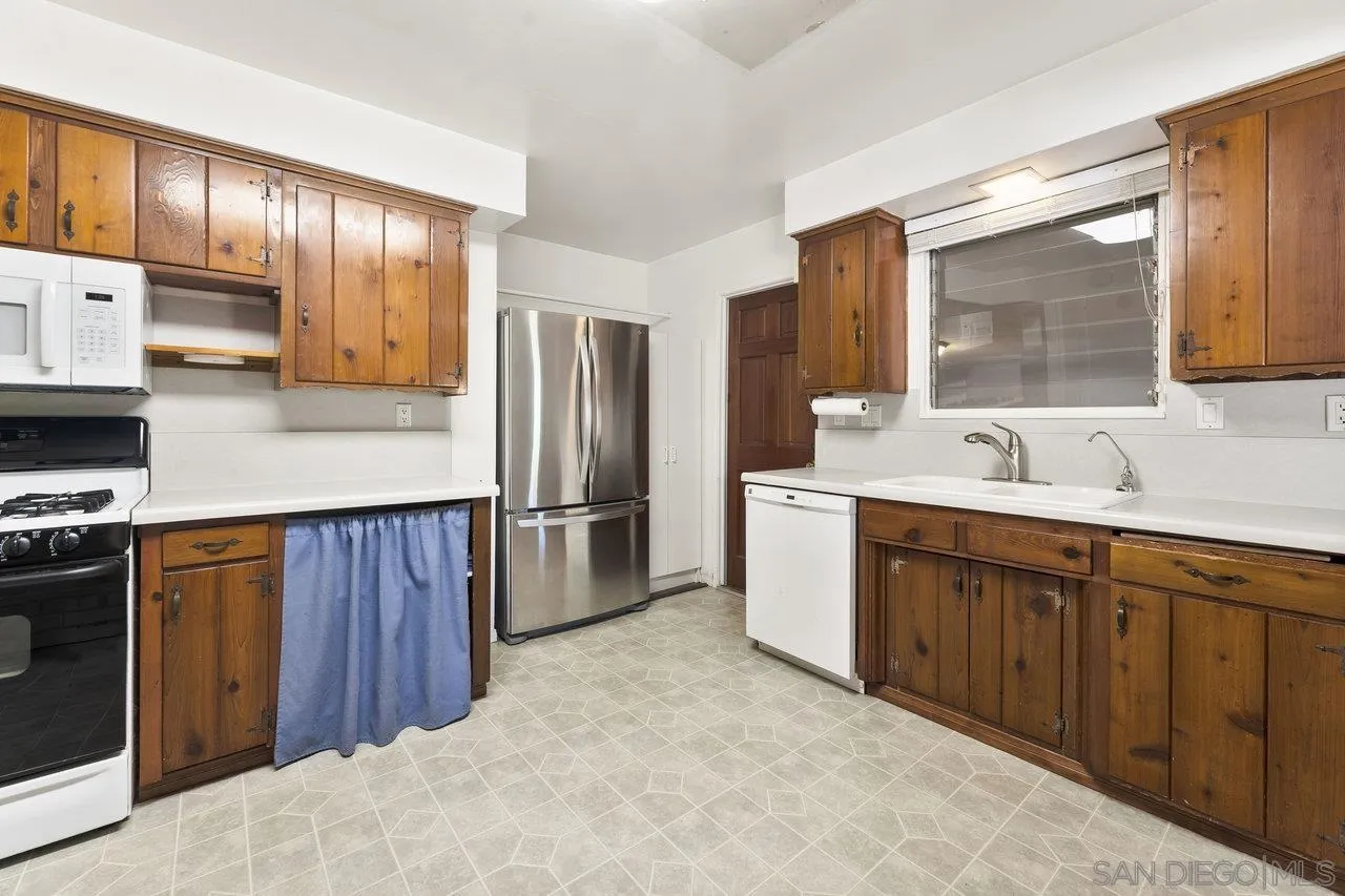 1822 Wight Way El Cajon, CA 92021 - Photo 13 of 45 a kitchen with stainless steel appliances granite countertop a refrigerator stove and sink