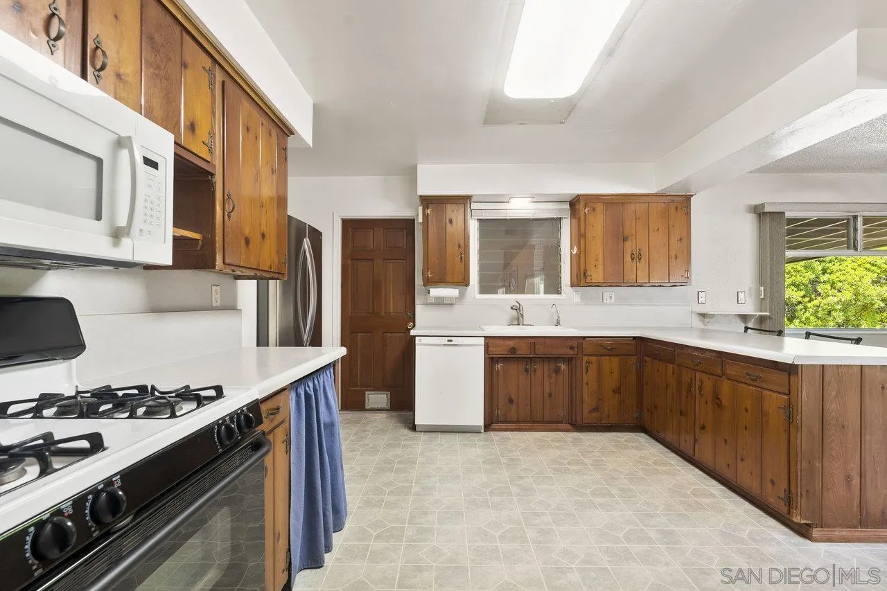 1822 Wight Way El Cajon, CA 92021 - Photo 14 of 45 a kitchen with a stove a sink and a refrigerator
