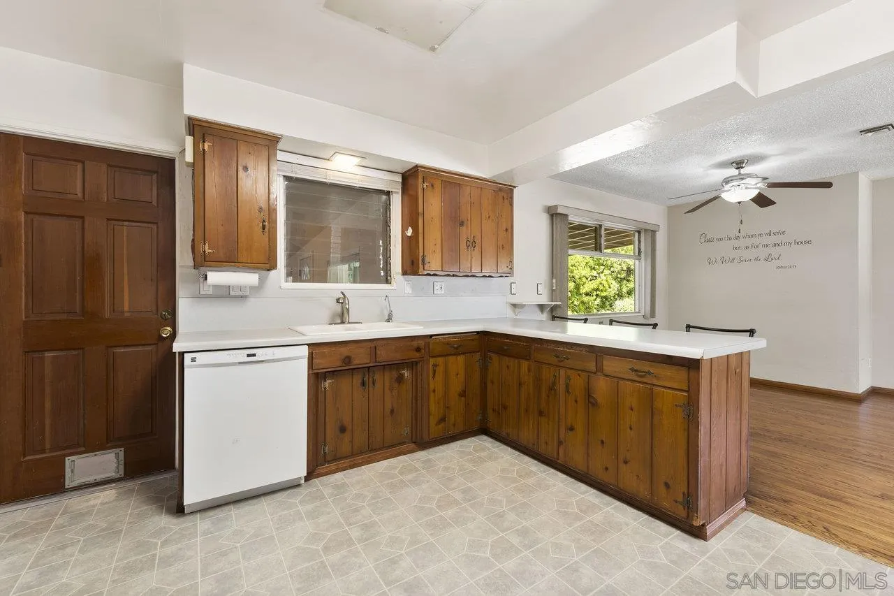 1822 Wight Way El Cajon, CA 92021 - Photo 15 of 45 a kitchen with stainless steel appliances granite countertop a refrigerator a sink dishwasher and wooden cabinets with wooden floor