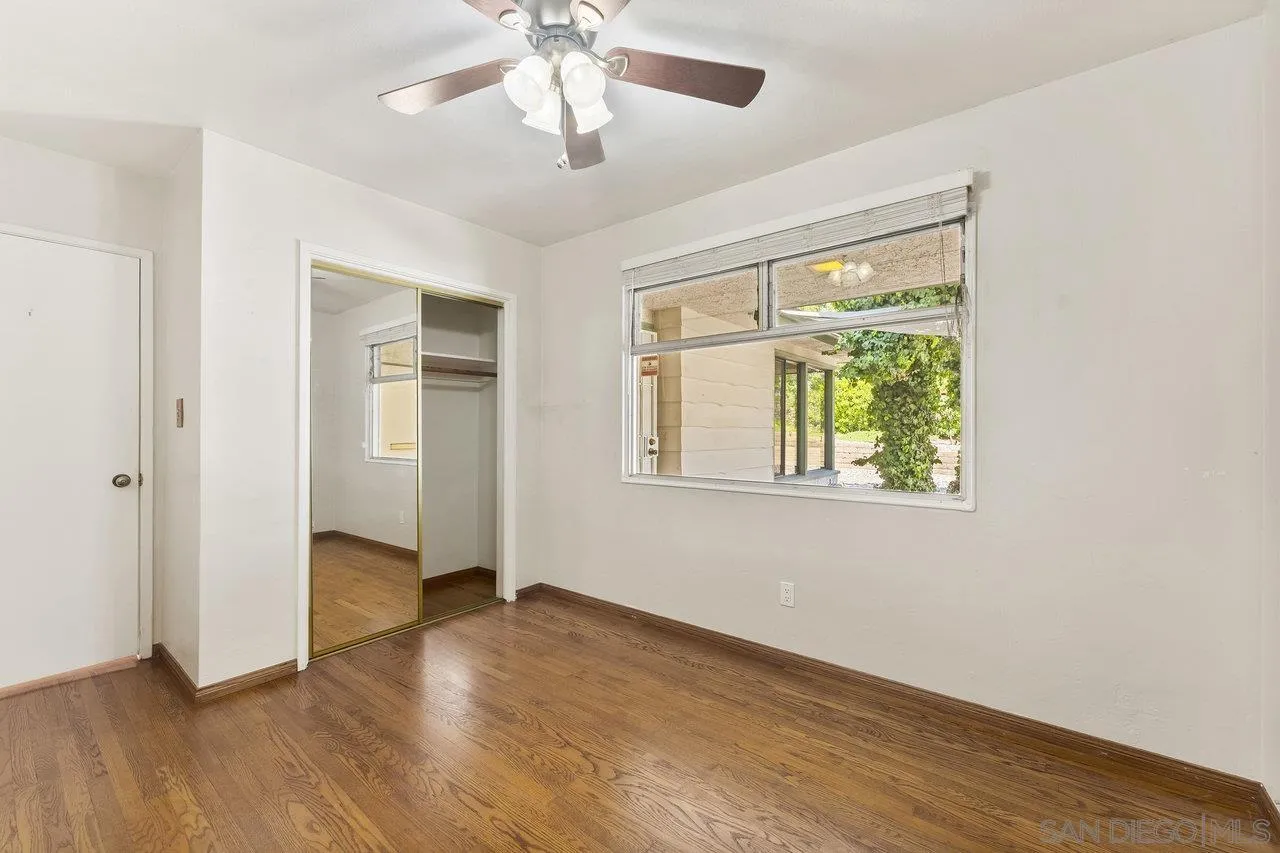 1822 Wight Way El Cajon, CA 92021 - Photo 18 of 45 an empty room with wooden floor chandelier and windows