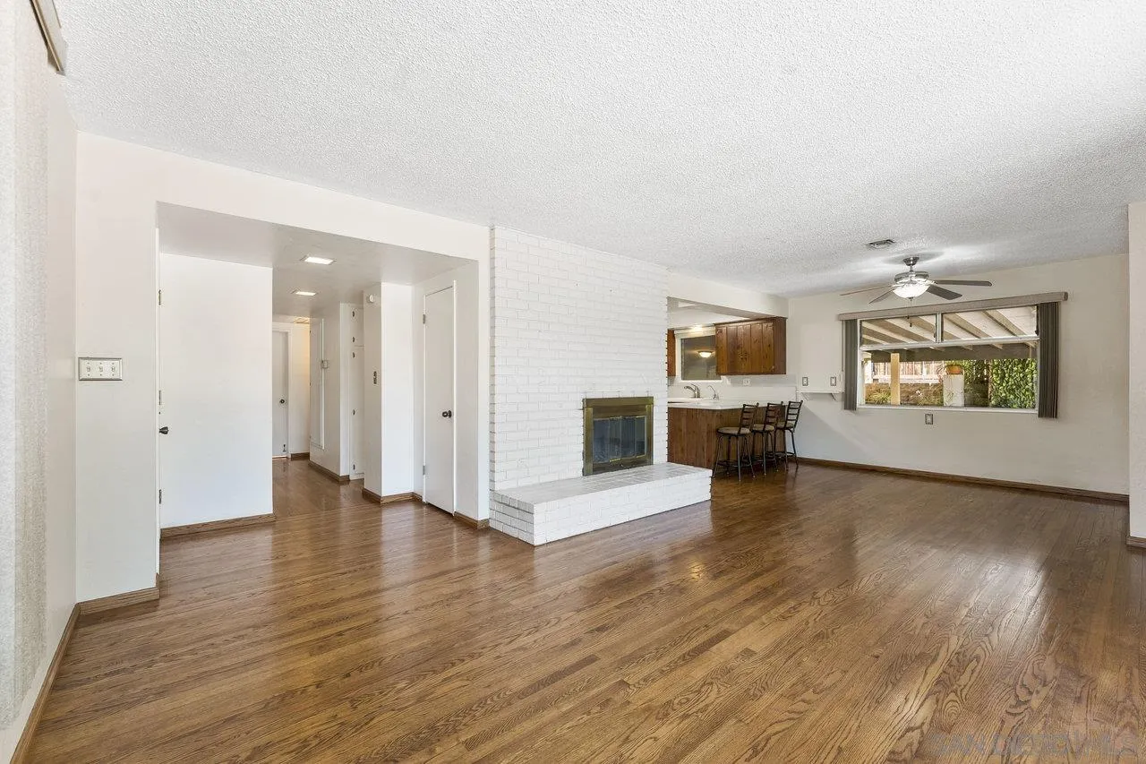 1822 Wight Way El Cajon, CA 92021 - Photo 8 of 45 an empty room with wooden floor fire place and windows