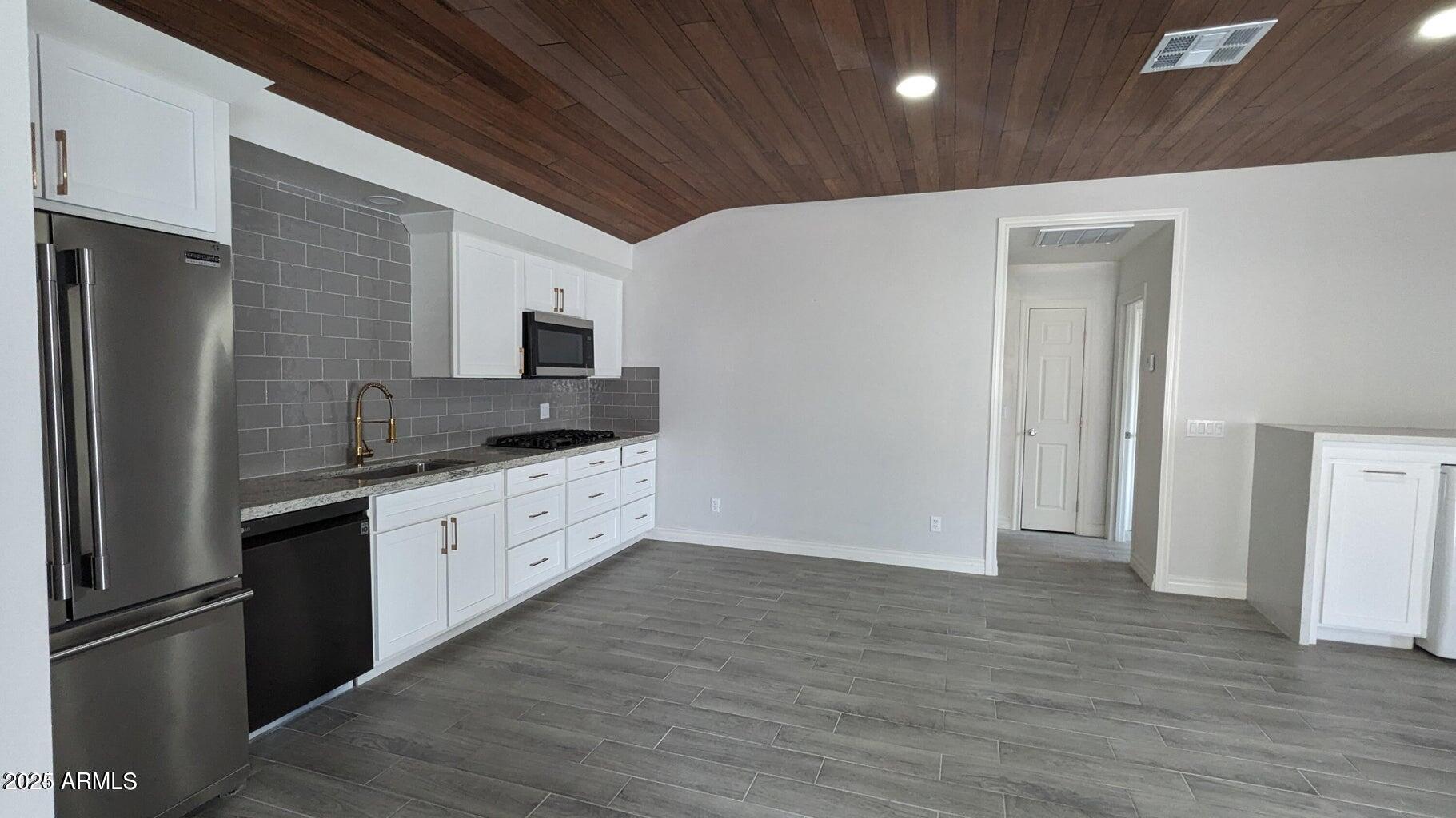224 South Adonis Avenue Miami, AZ 85539 - Photo 4 of 13 a large kitchen with stainless steel appliances granite countertop a refrigerator and a stove top oven