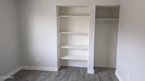 a view of walk in closet with empty racks