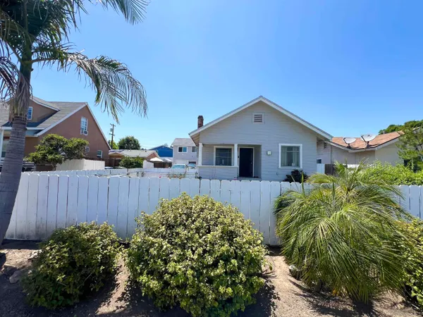 a front view of a house with a yard and plants