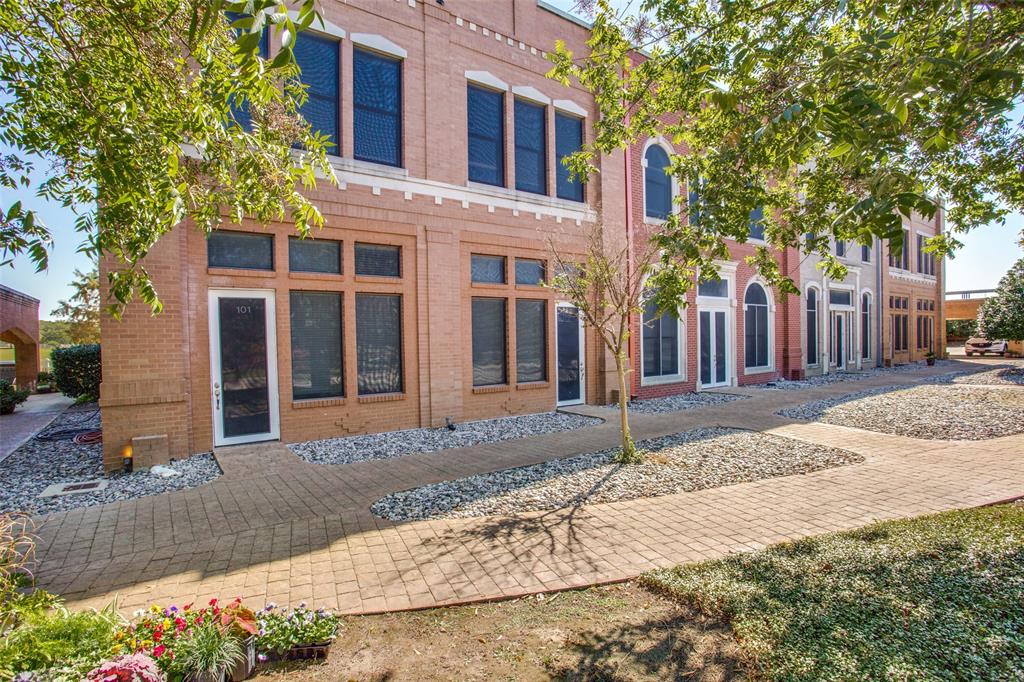11351 Hilltop Road, Unit 101 Argyle, TX 76226 - Photo 1 of 1 a view of a brick building next to a yard