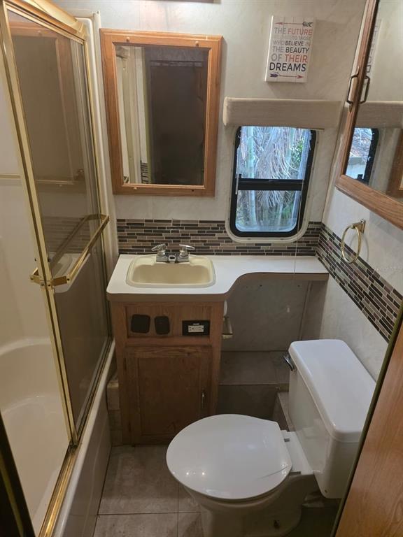 3000 Clarcona Road, Unit 770 Apopka, FL 32703 - Photo 4 of 5 a bathroom with a toilet sink and mirror