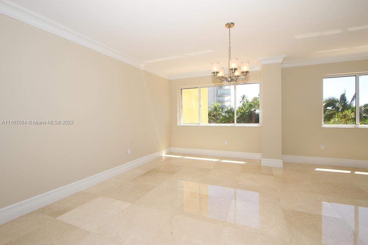 650 Ocean Drive, Unit 3C Key Biscayne, FL 33149 - Photo 5 of 16 an empty room with windows and chandelier