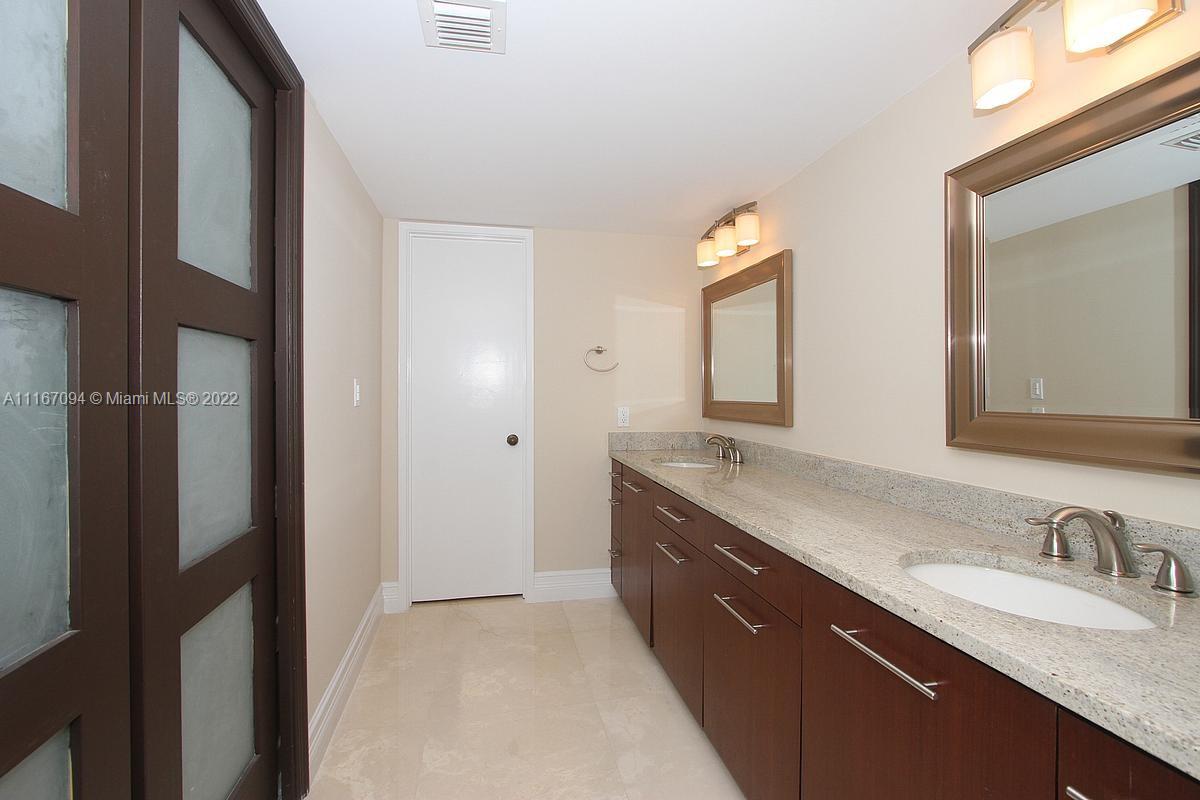 650 Ocean Drive, Unit 3C Key Biscayne, FL 33149 - Photo 9 of 16 a bathroom with a granite countertop double vanity sink and a mirror
