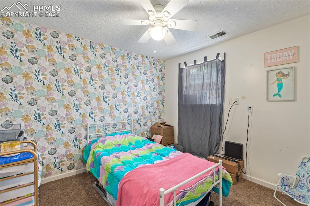 732 South Chestnut Street Elizabeth, CO 80107 - Photo 22 of 26 a bedroom with a bed and a chandelier
