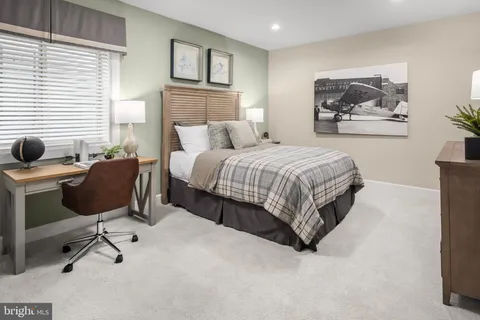 a spacious bedroom with a bed a table and chair