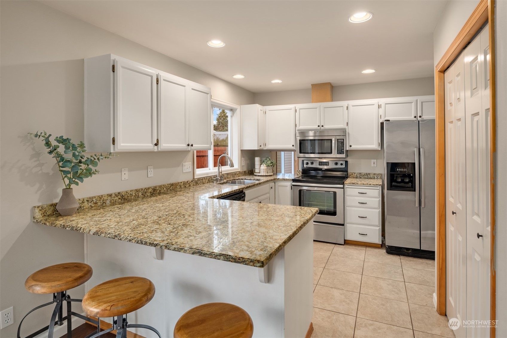 8722 Bowdoin Way Edmonds, WA 98026 - Photo 11 of 40 a kitchen with stainless steel appliances granite countertop a sink a stove a refrigerator a washer and dryer