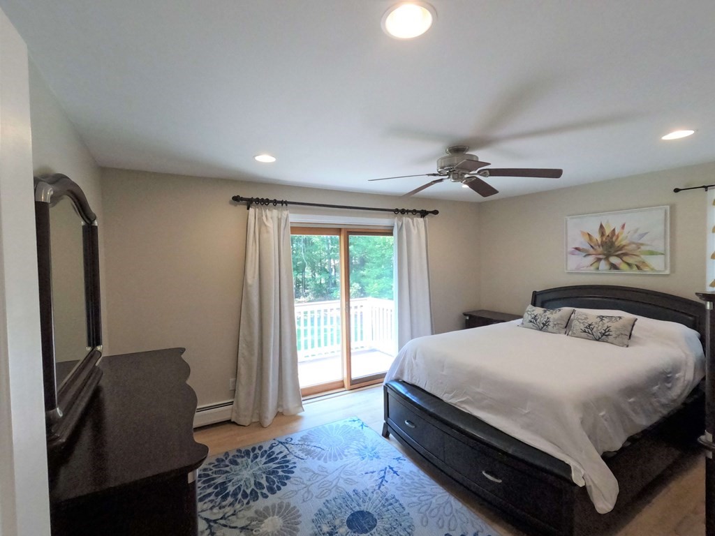 262 Flag Swamp Road Dartmouth, MA 02747 - Photo 16 of 23 a bedroom with a bed and a dresser with wooden floor