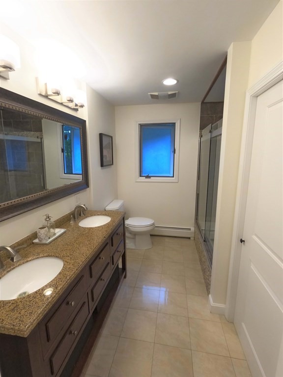 262 Flag Swamp Road Dartmouth, MA 02747 - Photo 20 of 23 a bathroom with a granite countertop sink a toilet a mirror and vanity