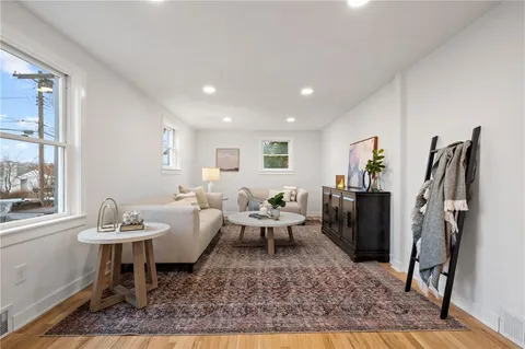 a living room with furniture a rug and a window