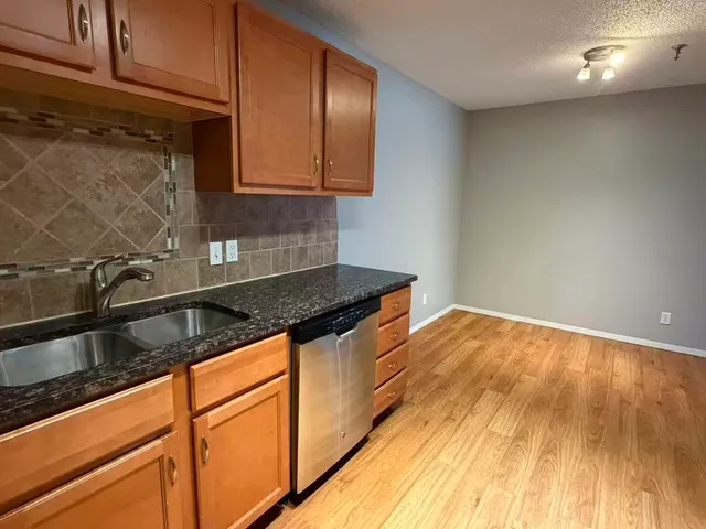 a kitchen with granite countertop a sink and cabinets