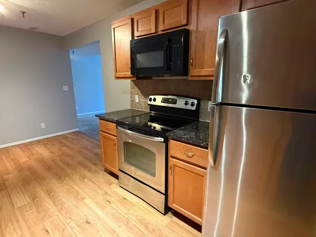 a kitchen with stainless steel appliances a refrigerator stove and microwave