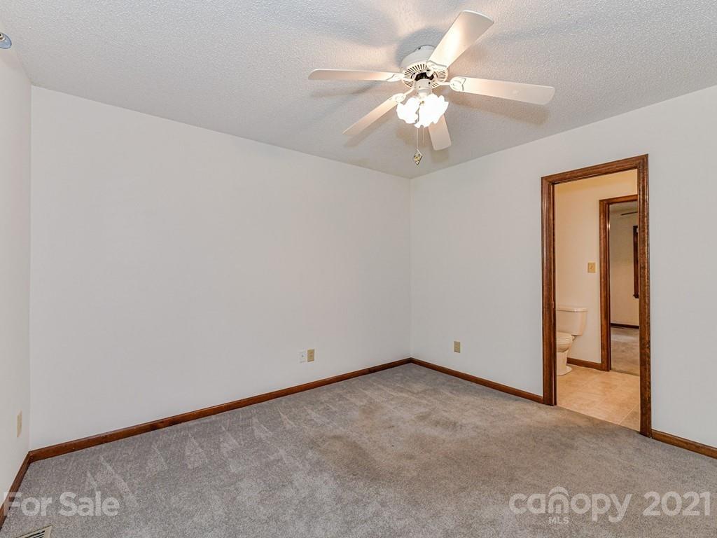 123 West Sandy Ridge Road Monroe, NC 28112 - Photo 22 of 32 an empty room with a chandelier fan and windows