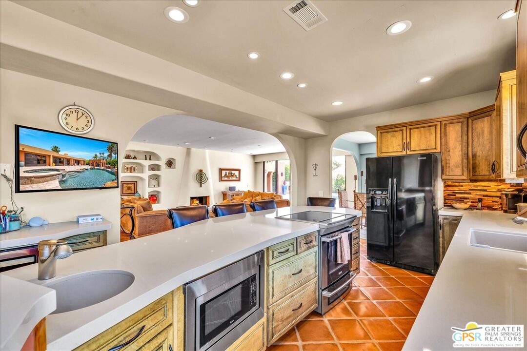 71121 Sunny Lane Rancho Mirage, CA 92270 - Photo 23 of 75 a kitchen with stainless steel appliances granite countertop sink stove and refrigerator