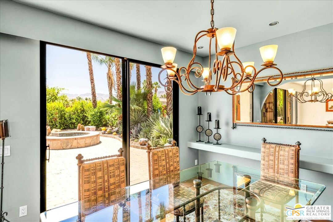 71121 Sunny Lane Rancho Mirage, CA 92270 - Photo 28 of 75 a view of a dining room with furniture a chandelier and a large window
