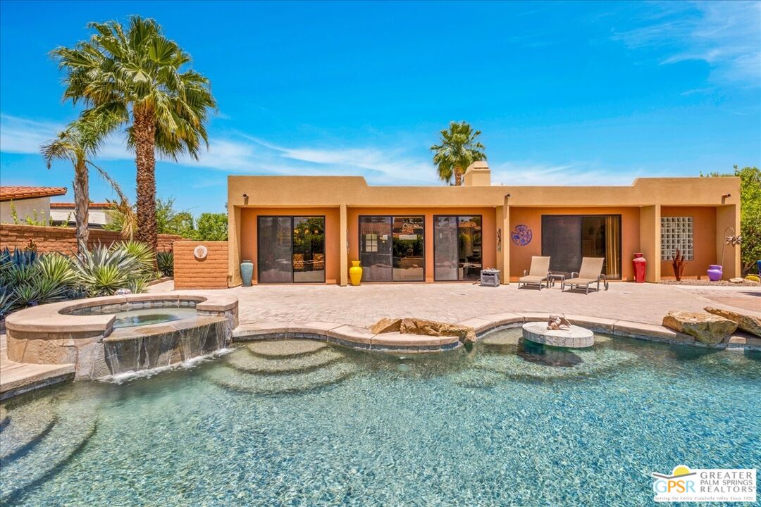 71121 Sunny Lane Rancho Mirage, CA 92270 - Photo 49 of 75 a view of a white house with a swimming pool and wooden fence