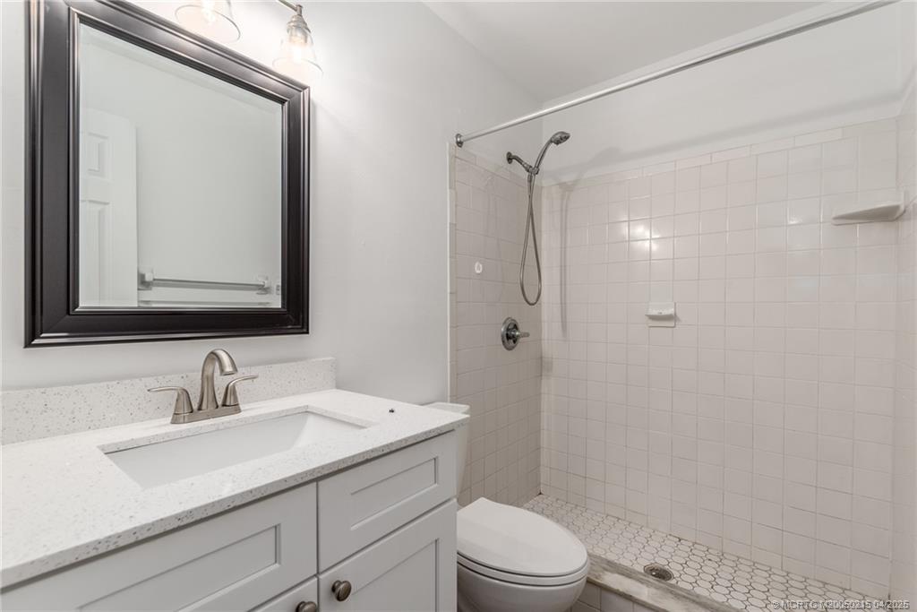 644 Southwest Cleveland Avenue, Unit 6 Stuart, FL 34994 - Photo 11 of 22 a bathroom with a sink a toilet a mirror and shower