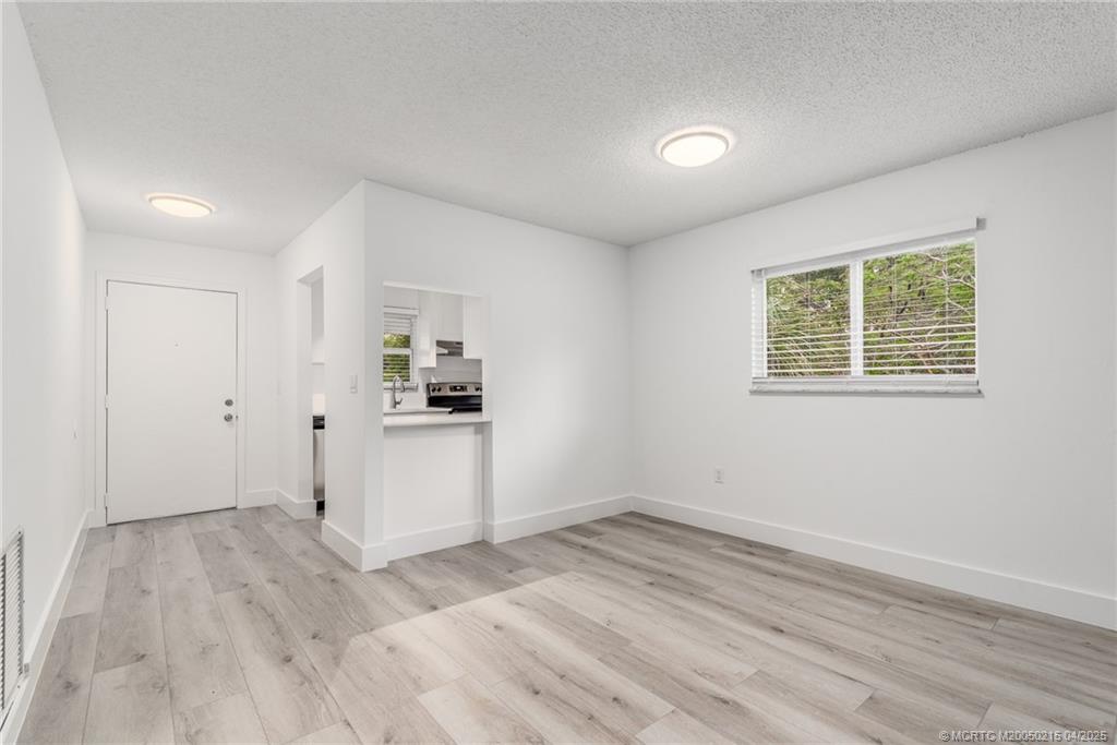 644 Southwest Cleveland Avenue, Unit 6 Stuart, FL 34994 - Photo 3 of 22 a view of a kitchen with wooden floor and windows