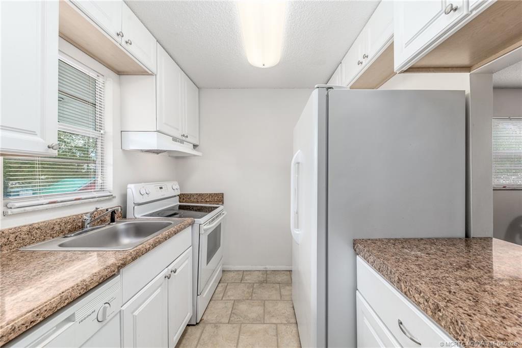 644 Southwest Cleveland Avenue, Unit 6 Stuart, FL 34994 - Photo 9 of 22 a kitchen with stainless steel appliances granite countertop a sink stove and refrigerator