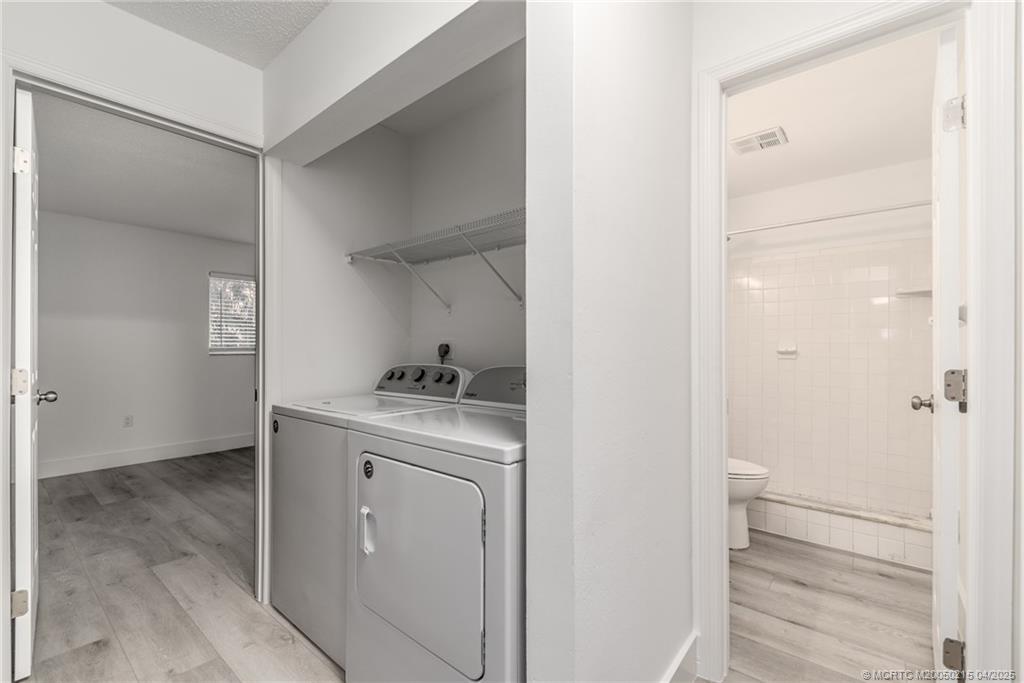 644 Southwest Cleveland Avenue, Unit 6 Stuart, FL 34994 - Photo 10 of 22 a utility room with cabinets washer and dryer