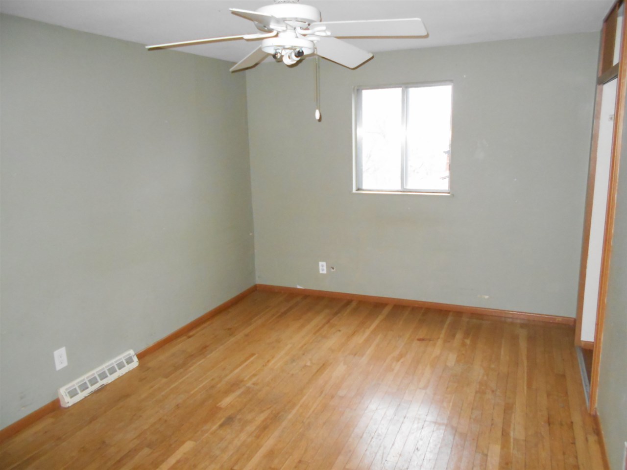 1017 Kenmore Road Rockford, IL 61108 - Photo 6 of 9 a view of an empty room with wooden floor and a window