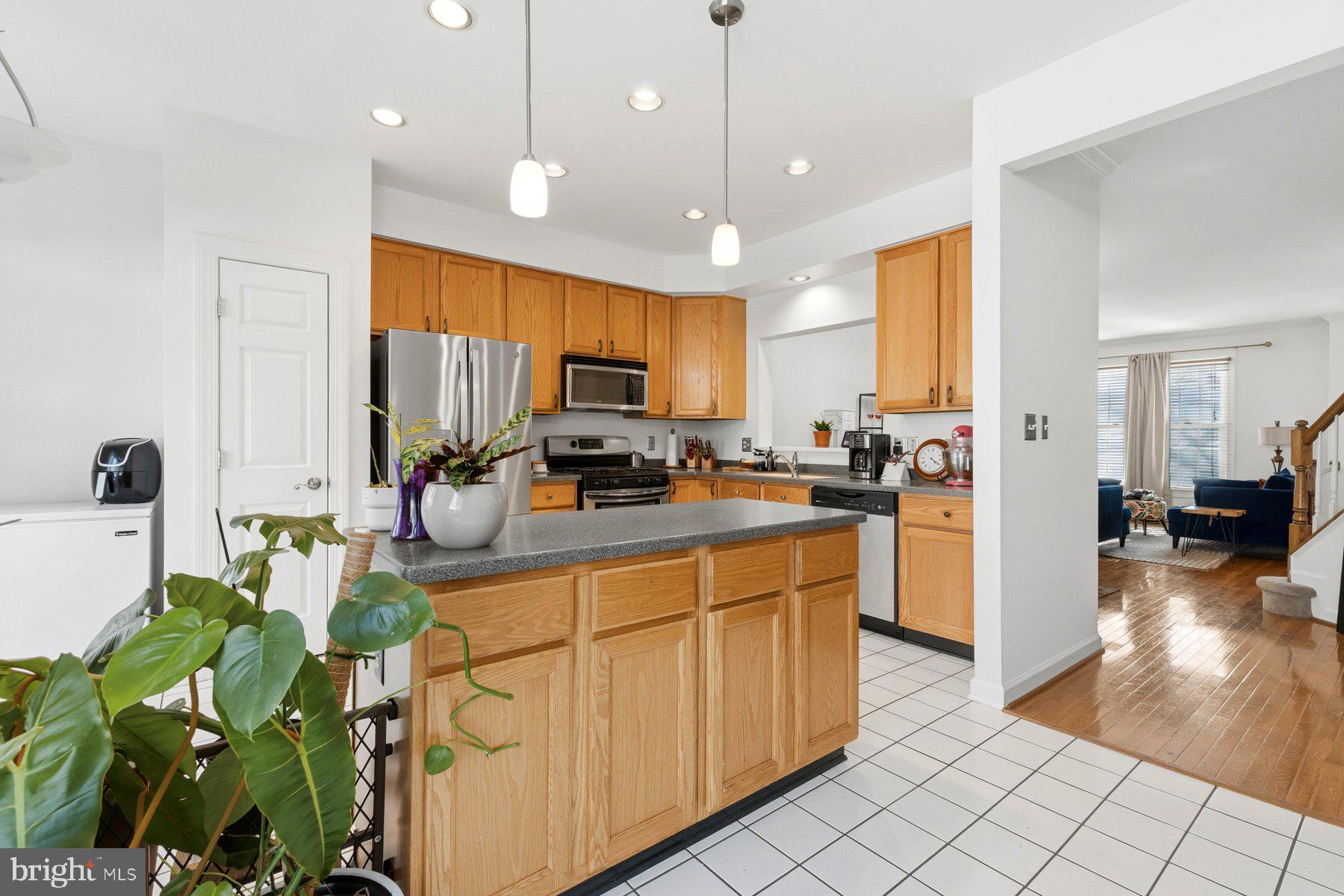 3632 Ransom Place Alexandria, VA 22306 - Photo 12 of 33 a kitchen with stainless steel appliances granite countertop sink stove and white cabinets with wooden floor