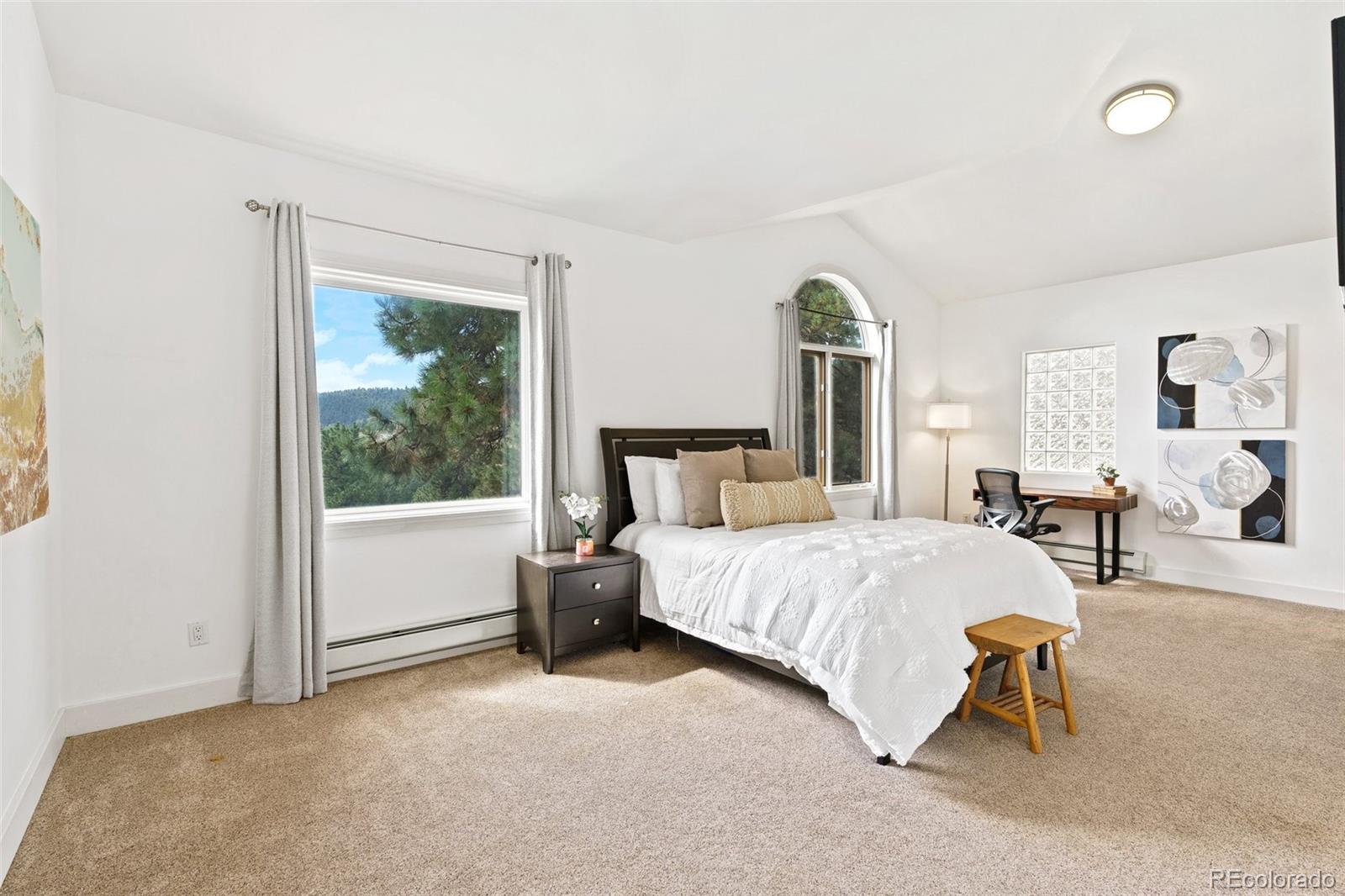 24140 Highway 40 Golden, CO 80401 - Photo 15 of 40 a spacious bedroom with a bed and a chandelier