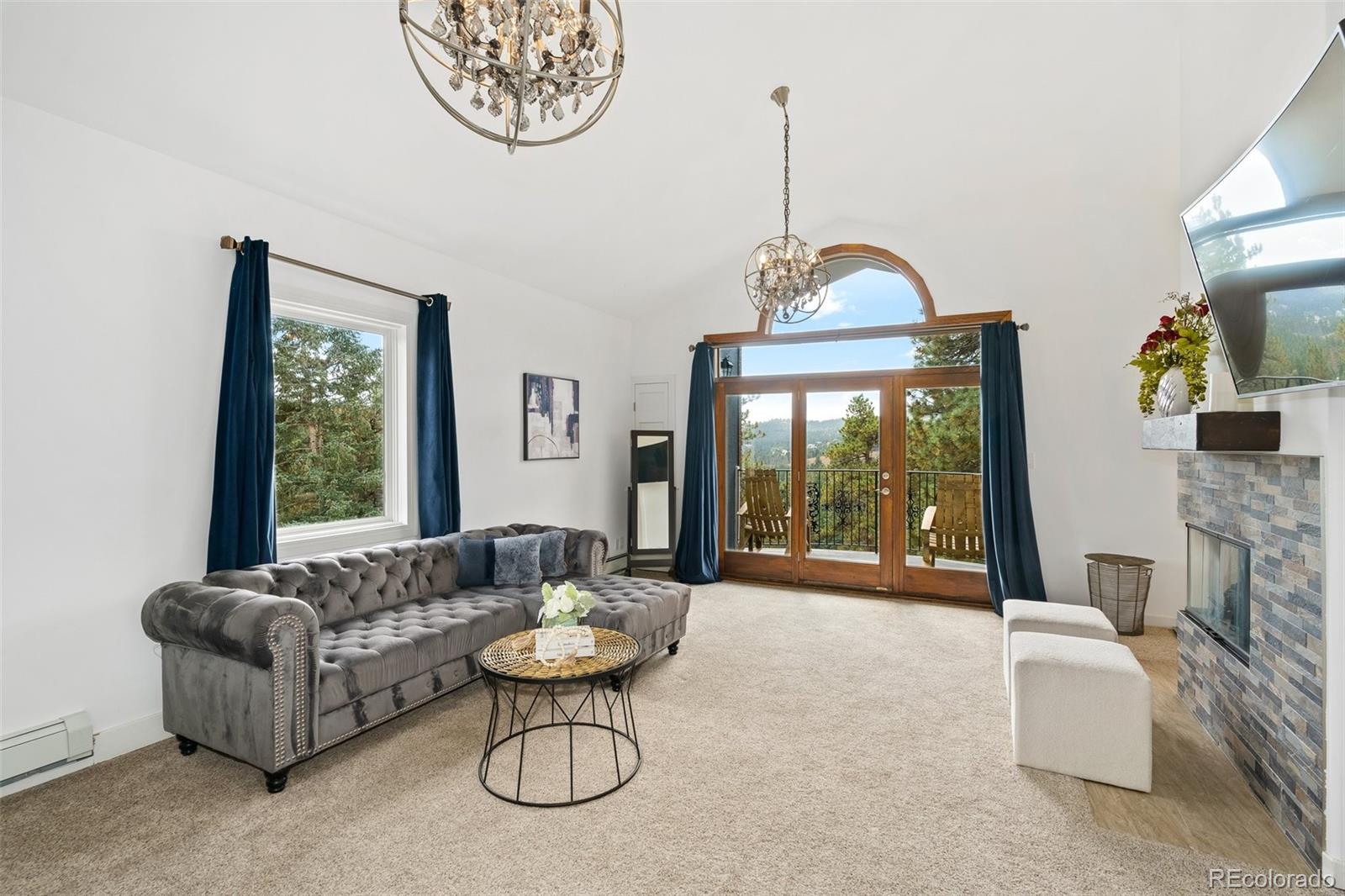 24140 Highway 40 Golden, CO 80401 - Photo 23 of 40 a living room with furniture a fireplace and a chandelier