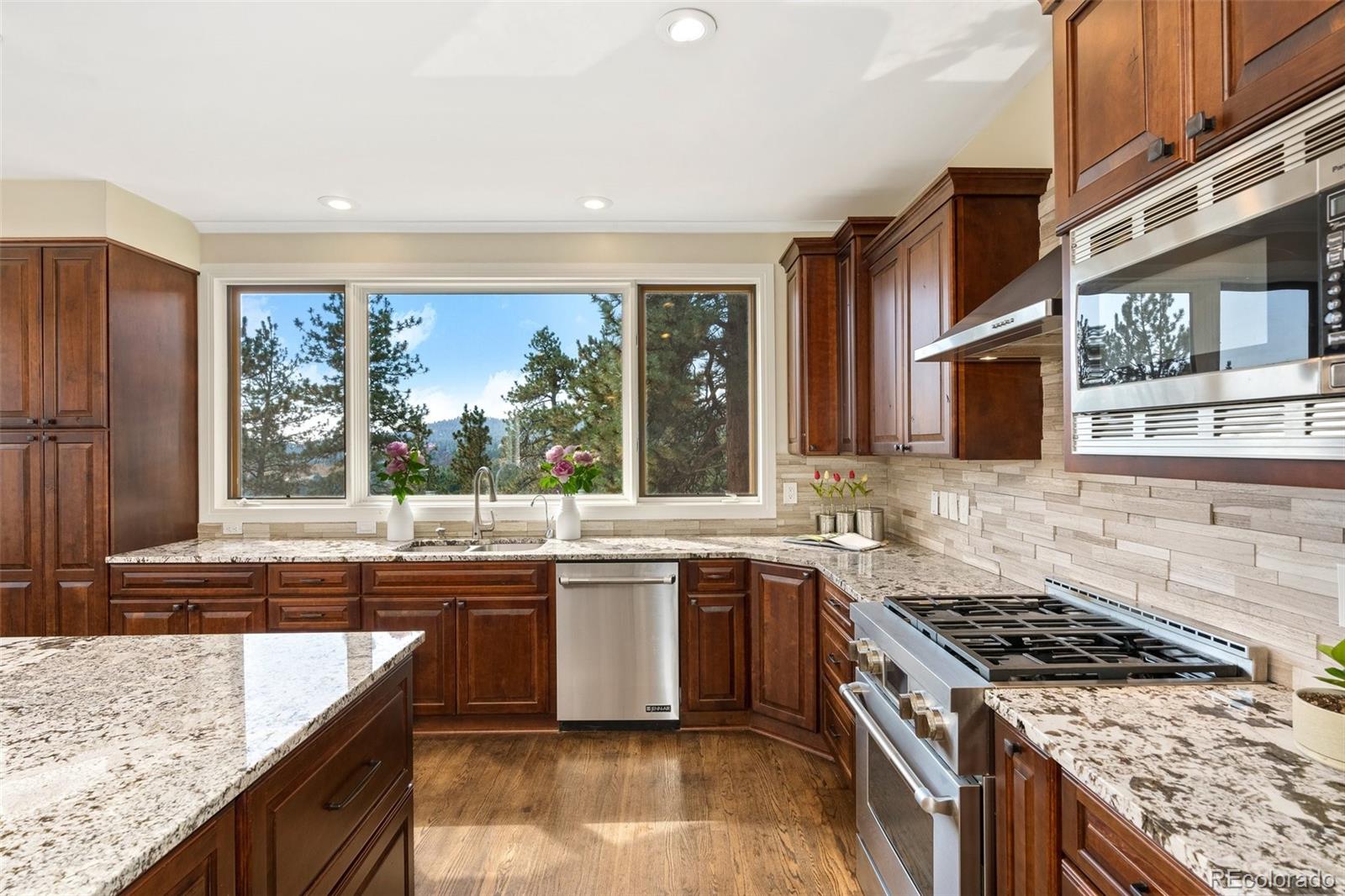 24140 Highway 40 Golden, CO 80401 - Photo 10 of 40 a kitchen with stainless steel appliances granite countertop a stove a sink and a microwave