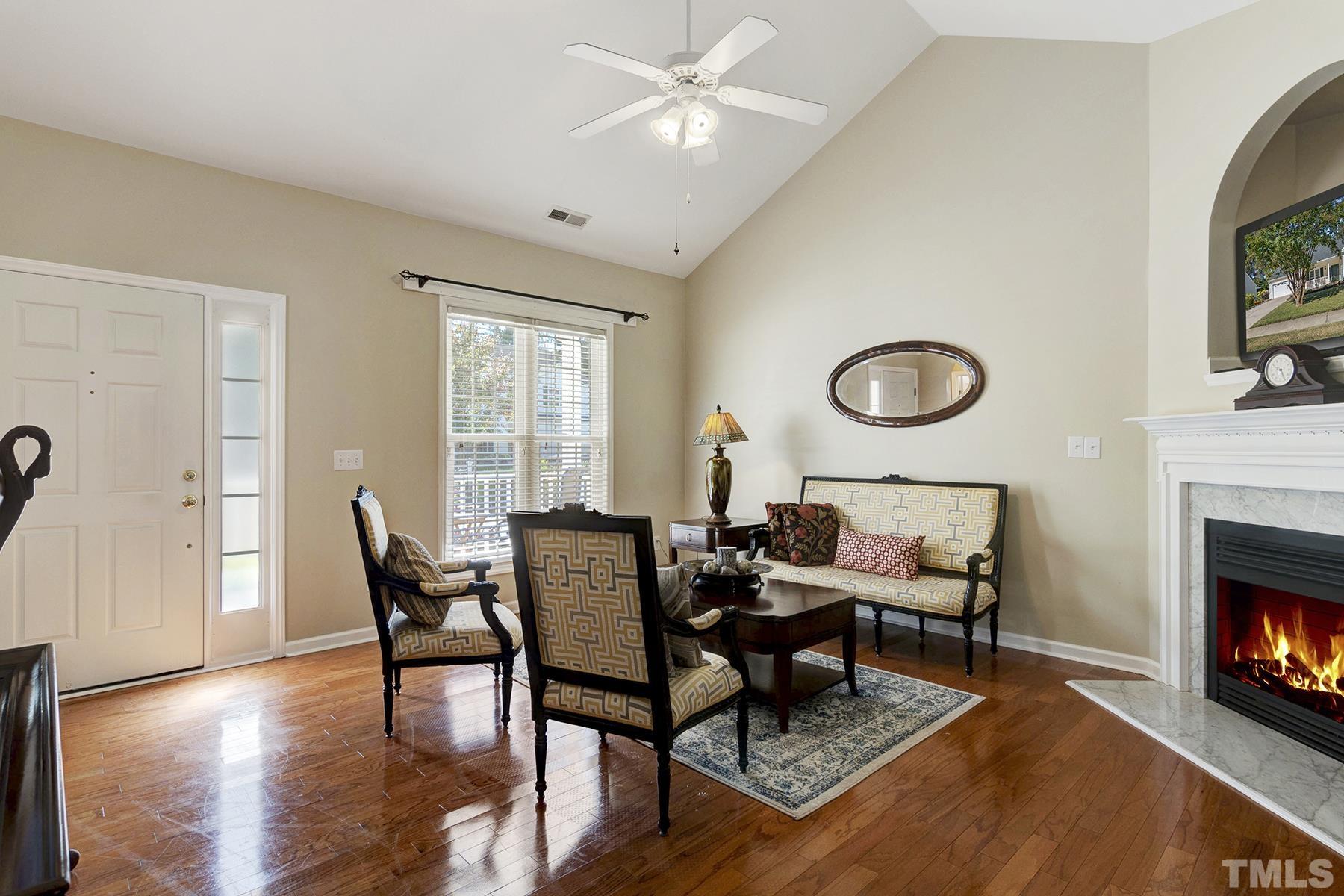 5413 Neuse Forest Road Raleigh, NC 27616 - Photo 9 of 27 a living room with furniture a fireplace and a flat screen tv