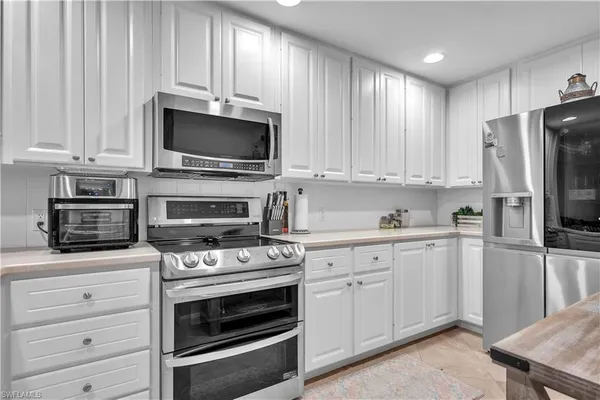 a kitchen with white cabinets and stainless steel appliances
