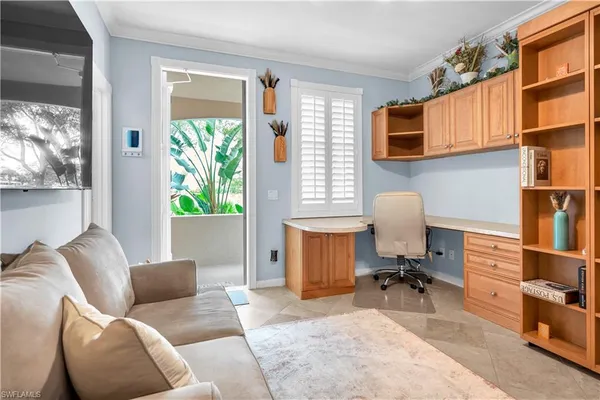 a living room with furniture a bookshelf and a window