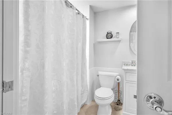 a white toilet sitting next to a shower curtain