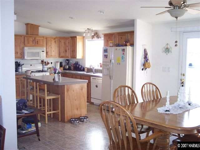 6805 Winnemucca Ranch Road Reno, NV 89510 - Photo 3 of 9 a kitchen with sink refrigerator dining table and chairs