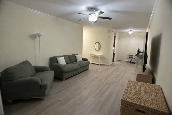 a living room with furniture and a wooden floor