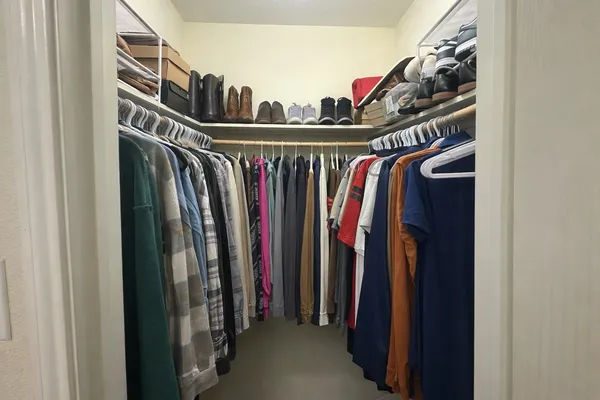 a view of walk in closet with clothes