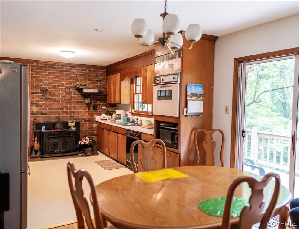 12808 South Chester Road Chester, VA 23831 - Photo 5 of 32 a kitchen with stainless steel appliances kitchen island granite countertop a stove a refrigerator a dining table and chairs with wooden floor