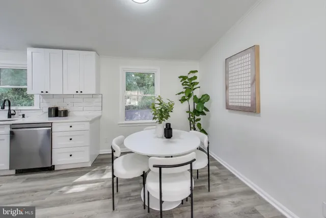 a kitchen with a white table and chairs