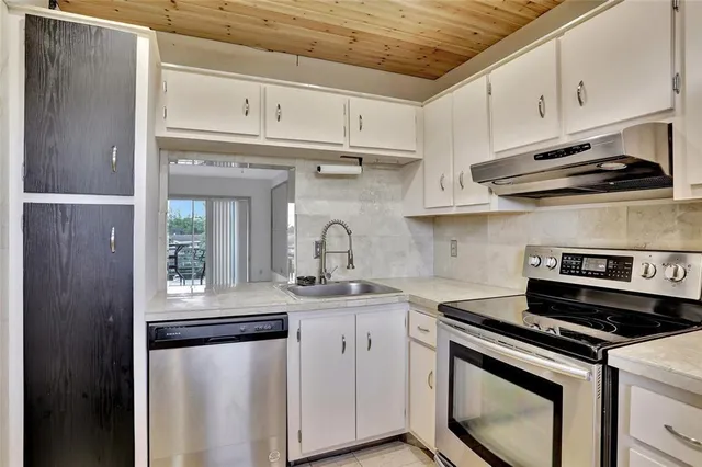 a kitchen with stainless steel appliances granite countertop a sink stove and cabinets