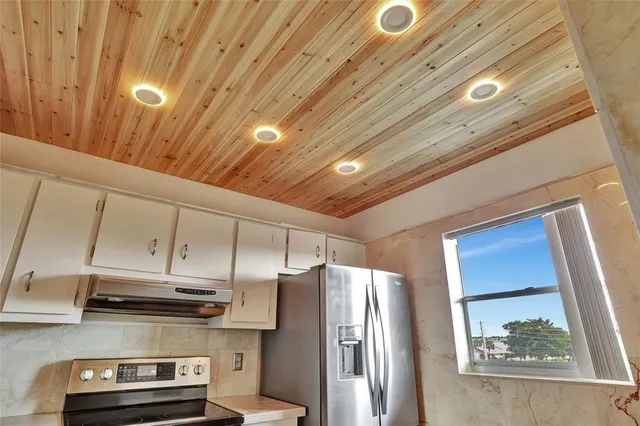 a kitchen with stainless steel appliances a stove a refrigerator and cabinets