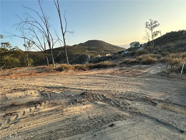 a view of a dry yard with lots of bushes