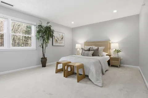 a spacious bedroom with a bed and a window