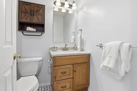 a bathroom with a toilet a sink and mirror