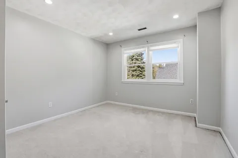 an empty room with windows and closet
