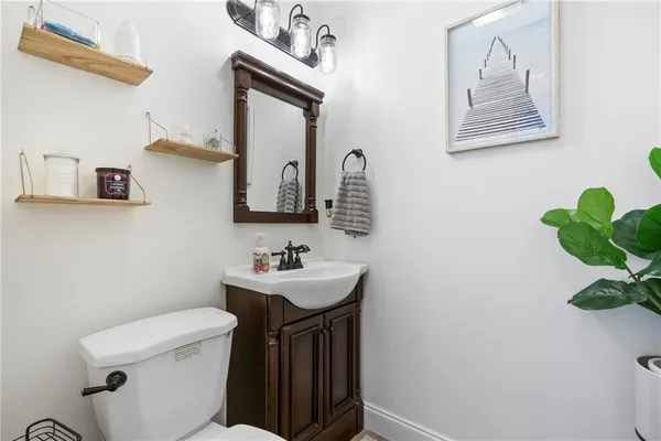 a bathroom with a toilet a sink and mirror